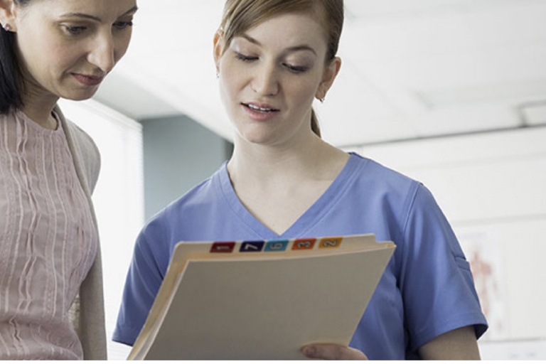 Médecin et patient regardant un dossier médical